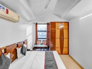 - une chambre avec un lit, une chaise et une fenêtre dans l'établissement HOTEL GEESON INTERNATIONAL-New Delhi Railway Station-Paharganj, à New Delhi