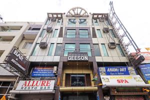 un grand bâtiment sur une rue de la ville avec des panneaux dans l'établissement HOTEL GEESON INTERNATIONAL-New Delhi Railway Station-Paharganj, à New Delhi