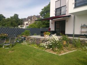 einen Hinterhof mit einer steinernen Mauer und einem Rasen in der Unterkunft Ferienwohnung Sayntalblick in Caan