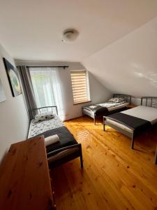 two beds in a room with wooden floors at Wigierska Osada in Danowskie