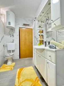 une salle de bain blanche avec un lavabo et des toilettes dans l'établissement Apartments Hajl, à Krk