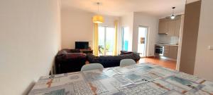 a kitchen and a living room with a table and chairs at Ocean & Nature Flat - Aljezur - Algarve West Coast - 1,6km Praia Monte Clérigo in Aljezur