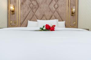 a bedroom with a bed with a red rose on it at Rihanna Hotel Apartment in Kuwait