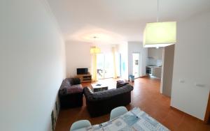 a living room with two couches and a table at Ocean & Nature Flat - Aljezur - Algarve West Coast - 1,6km Praia Monte Clérigo in Aljezur