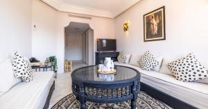 ein Wohnzimmer mit einem Sofa und einem Tisch in der Unterkunft Charming 2-Bed Oasis Pool View in Marrakesch