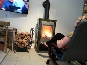 ドウゴポレ・ズドルイにあるSpa Park Guest Roomsの暖炉の前に座る女
