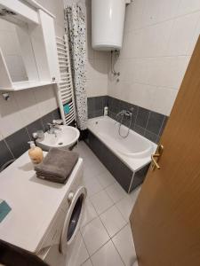 ein Badezimmer mit einer Waschmaschine und einem Waschbecken in der Unterkunft Index Apartman in Banja Luka