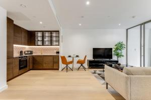 a living room with a couch and a kitchen at Khayat Homes - The Ostrich - One Bed Luxury Apt in London