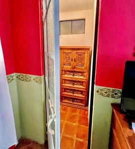 a room with a closet with red and green walls at Casa Camellia in San Miguel de Allende