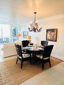 a dining room table with chairs and a chandelier at Wake Up To The Sounds Of The Sea in Freeport