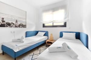 a bedroom with two beds and a blue couch at Playa Carabassi Sea View Apartment in Gran Alacant, Large Terrace in Gran Alacant +26 photos
