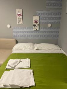 ベナルマデナにあるBenalmadena ,apartamento-Estudio primera Línea de Playaのベッド1台(緑の毛布、タオル2枚付)