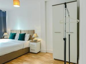 a bedroom with a large bed with blue pillows at Deluxe 3 Bed Flat with garden in Finchley