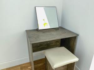 a wooden table with a stool and a mirror at Deluxe 3 Bed Flat with garden in Finchley