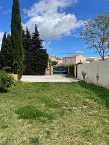 a yard with a driveway and a house at Grande maison 132m2 avec jardin et piscine à 15min de la plage in La Crau