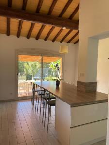 a kitchen with a counter with chairs and a table at Grande maison 132m2 avec jardin et piscine à 15min de la plage in La Crau