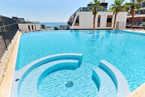 a large blue swimming pool on top of a building at Playa Carabassi Sea View Apartment in Gran Alacant, Large Terrace in Gran Alacant