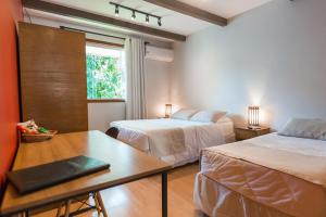 una habitación de hotel con dos camas y una mesa en Hotel Serra Everest, en Nova Friburgo 232 fotos más