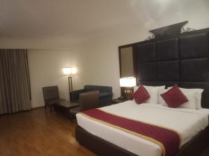 a hotel room with a large bed with red pillows at Hotel Comfortel Banjara Hills- Free Buffet breakfast- Multi Cuisine Restauran- An Svm Brand in Hyderabad