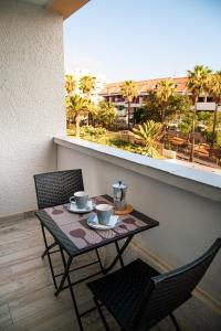 a small table and chairs on a balcony with a view at DANICO PLAYA HONDA 218 in Playa de las Americas