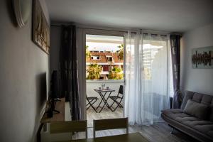 a living room with a couch and a balcony with a table at DANICO PLAYA HONDA 218 in Playa de las Americas