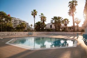 a swimming pool in a courtyard with palm trees at DANICO PLAYA HONDA 218 in Playa de las Americas