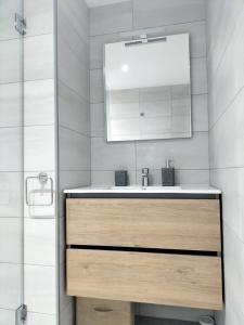a bathroom with a sink and a mirror at Enjoy Morro Jable in Morro del Jable +18 photos