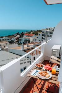 a balcony with two plates of food on a table at Casa Amar- Vista panorâmica in Luz