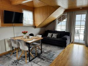 a living room with a table and a couch at Fewo-zum-Nussbaum - Mosel 2 in Schweich