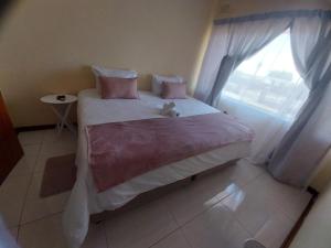 a bedroom with a large bed with a window at Sweet home guesthouse in Mthatha