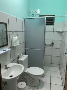 a white bathroom with a toilet and a sink at Pousada Morada dos Pássaros in Caraguatatuba
