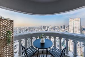 a balcony with a table and chairs and a city at Iconic skyline, Big apartment, Great location in Bangkok