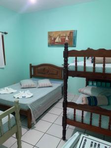 2 stapelbedden in een kamer met blauwe muren bij Pousada Morada dos Pássaros in Caraguatatuba