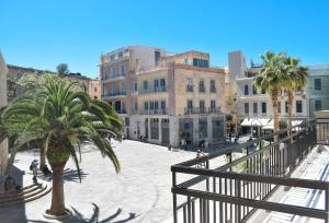 una calle de la ciudad con una palmera y edificios en Pagopoieion - Adults Only Suites, en Heraclión