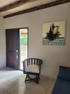 a chair in a living room with a painting on the wall at Casa de Campo Don Valentin in Tunuyán