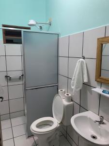 a bathroom with a toilet and a sink at Pousada Morada dos Pássaros in Caraguatatuba