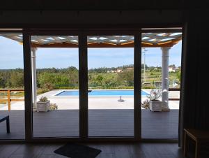 Blick auf den Pool durch eine Glasschiebetür in der Unterkunft Quinta da Fonte 