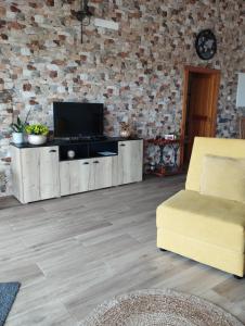 ein Wohnzimmer mit einem TV und einem gelben Stuhl in der Unterkunft Quinta da Fonte 