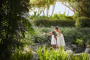 a woman and a little girl standing in a garden at JW Marriott Hotel Surabaya in Surabaya