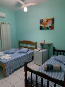 een slaapkamer met 2 bedden en een plafond bij Pousada Morada dos Pássaros in Caraguatatuba