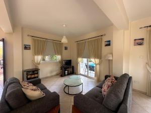 a living room with two couches and a table at Villa Demetra, Coral Bay in Coral Bay
