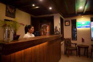 a woman sitting at a bar in a restaurant at Hotel Northfield in Kathmandu
