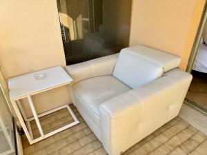a white couch in a room with a side table at Princess Palace Beach Monte-Carlo in Monte Carlo