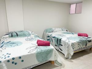 dos camas sentadas una al lado de la otra en una habitación en Posada Vacacional Brisas del Mar en Mazatlán