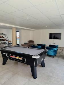 a pool table in a room with couches and a tv at Sunny Gibraltar in Gibraltar