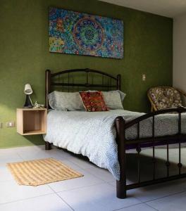 ein Schlafzimmer mit einem Bett und einem Wandgemälde in der Unterkunft Hermosa casa espaciosa y cómoda. Alberca en fracc. in Balvanera