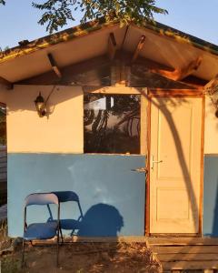 uma cadeira sentada em frente a uma casa em Camping Letea Himalaya em Letea