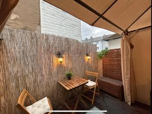 eine Terrasse mit Tisch und Stühlen und einem Zaun in der Unterkunft Trier City Center Apartments Altstadt in Trier
