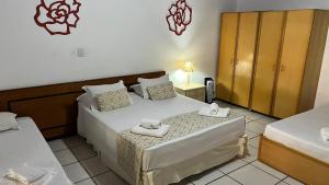 a bedroom with two beds with towels on them at Biazi Paradise Hotel in Serra Negra
