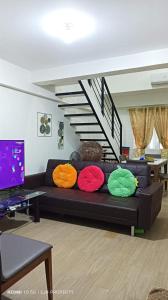 a couch with colorful pillows on it in a living room at Mactan Oasis Garden 401 in Mactan